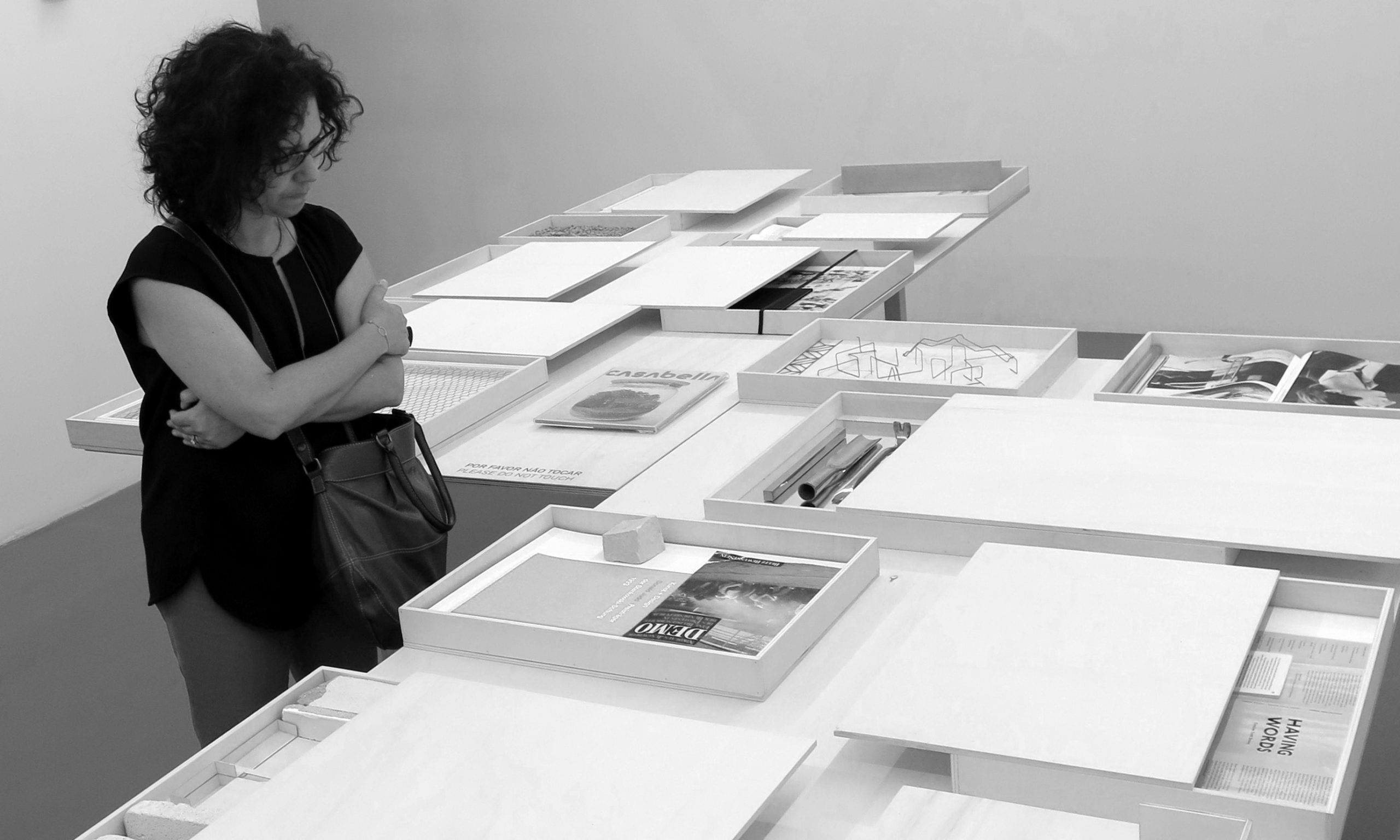 Black and white photograph. Rachael Arauz viewing work by artist Fernanda Fragateiro in Lisbon, 2017.