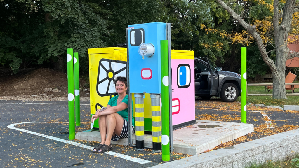 The artist in front of some of their public art.